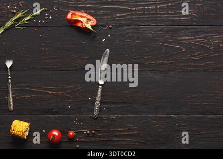 Cooking Ingredients and Utensils Arranged on a Dark Wooden Table for Meal Preparation Stock Photo