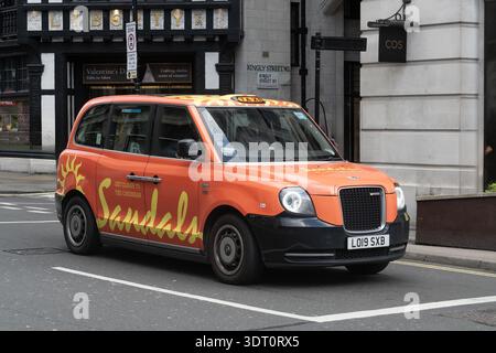 London, Uk - January 29, 2026 - London taxi with Sandals Resorts advertisement driving past Liberty store in central London, United Kingdom Stock Photo