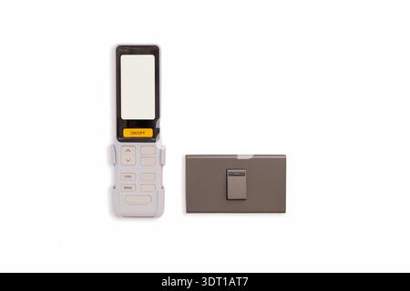 An air conditioner remote control with light switch setting on the wall. Close-up of an air conditioner remote with light switch, isolated on white , Stock Photo