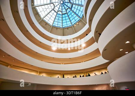 People walk along the spiral ramps of the Solomon R. Guggenheim Museum in Manhattan. The unique architecture draws attention. Stock Photo