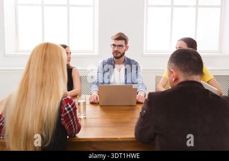 Meeting With Team Members Discussing Project Details at a Table in a Bright Room Stock Photo