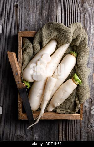 Daikon radish arranged on fabric and wood, white radish, farm fresh vegetables Stock Photo