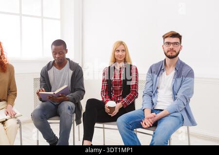 Group of People Sit in a Circle in Indoor Setting During Discussion at Social Event Stock Photo