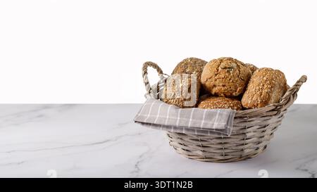 Fresh crispy bread rolls in the basket on a marble table. Background with a copy space Stock Photo