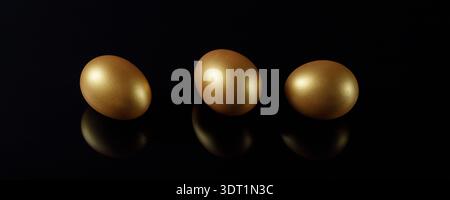 Happy easter dark glass background with three golden eggs and reflection. Black banner with copy space Stock Photo