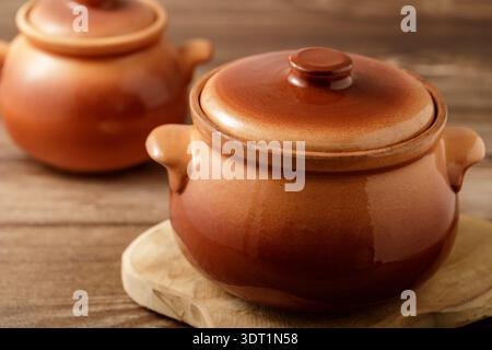 Ceramic pots for homemade baking dish on wooden table in the kitchen Stock Photo