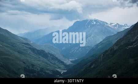Mountain Valley Landscape with Layered Ridges Under Cloudy Sky Stock Photo
