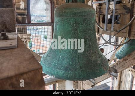 large bronze bell with religious relief and green oxidation inside the Bell Tower of St. Anastasia's Cathedral in Zadar, Croatia. Stock Photo