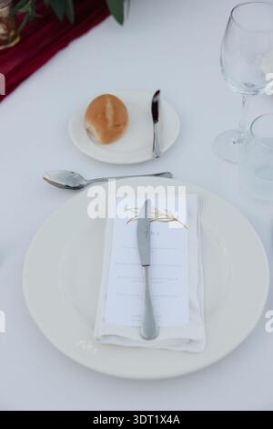 Minimal White Wedding Place Setting with Napkin and Bread Roll Stock Photo