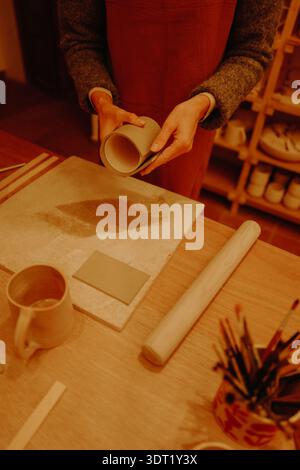 Young woman sculpting clay in pottery workshop Stock Photo