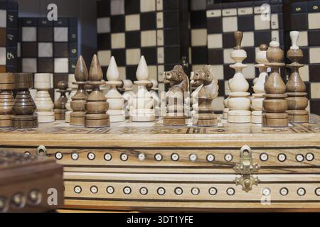 Wooden chess set with carved pieces displayed on decorative board Stock Photo