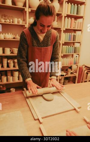 Young woman sculpting clay in pottery workshop Stock Photo