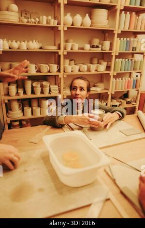 Young woman sculpting clay in pottery workshop Stock Photo