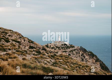 Distant View Of Formentor Lighthouse On Rocky Cliffs, Cap de Formentor Stock Photo