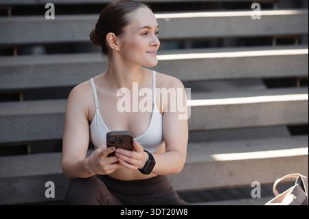 Fitness Woman Using Smartphone After Workout Stock Photo