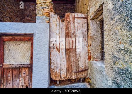 The small wooden shabby ruined doors on an abandoned house in Comano village, Switzerland Stock Photo
