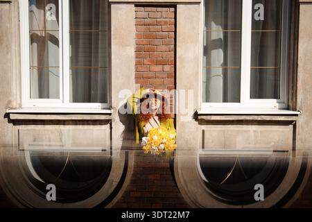 Woman with Flowers in Window Stock Photo