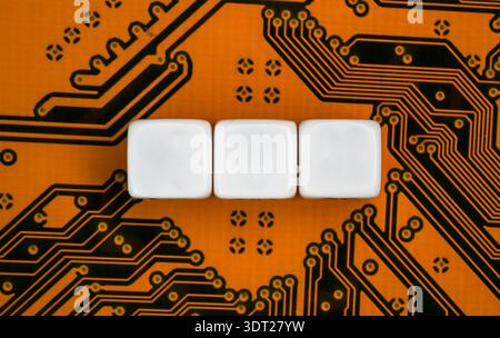 Electronic orange printed circuit board, with three empty white beads small cubes, detail view from above Stock Photo