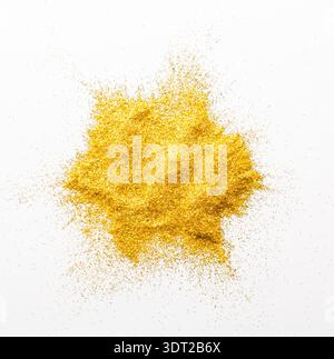 Collection of Golden Glitter Powder Arranged in a Circular Shape on a White Surface Stock Photo