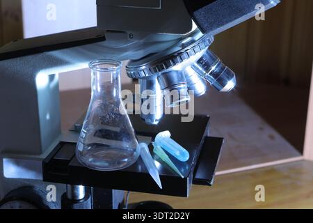 Microscope observing samples in a scientific laboratory setting with blue light Stock Photo