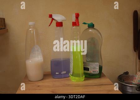 Cleaning liquid bottles and sprayers on wood surface, ready for domestic chores Stock Photo