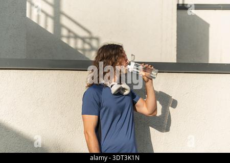 Man drinking water after workout outdoors Stock Photo