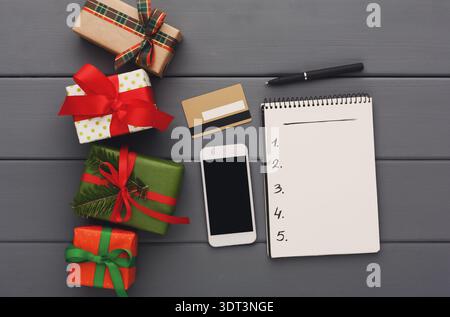 Holiday Gift Planning Collage With Presents, a Phone, and a Notepad on a Gray Surface Stock Photo