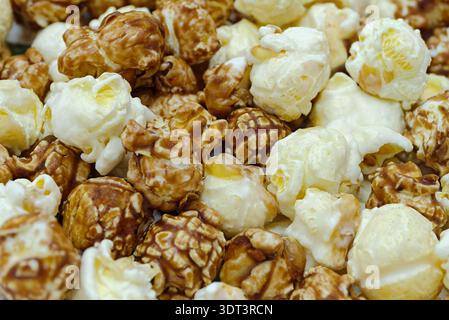 Pile of sweet popcorn coated in a rich caramel glaze with glossy texture and warm golden color. Close‑up shot, abstract food background for themes inv Stock Photo