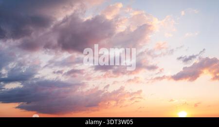 Dramatic clouds with sun rays breaking through sunset sky Stock Photo