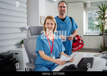 Healthcare professionals working in office smiling at camera Stock Photo