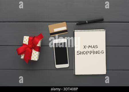 Collection of Items for Christmas Shopping on a Table With Gift, Phone, Pen, and Notes Stock Photo