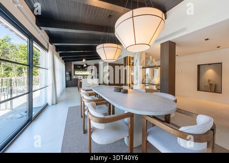 an image of a large oval stone dining table and matching chairs in luxurious mediterranean villa Stock Photo