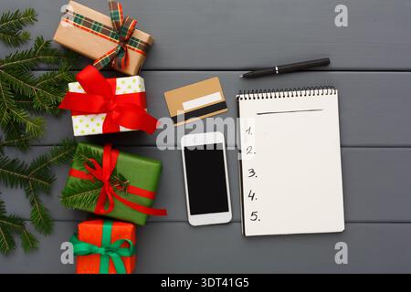Gift Planning Time With Presents and a Notepad on a Wooden Surface Stock Photo