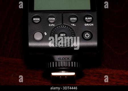 Close-up of camera flash control panel showing navigation buttons, control dial, and hot shoe mount Stock Photo