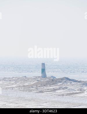 channel marker on frozen lake michigan Stock Photo