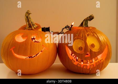 Close up of two hand carved Halloween pumpkins with goofy faces in a home in Vancouver Canada Stock Photo