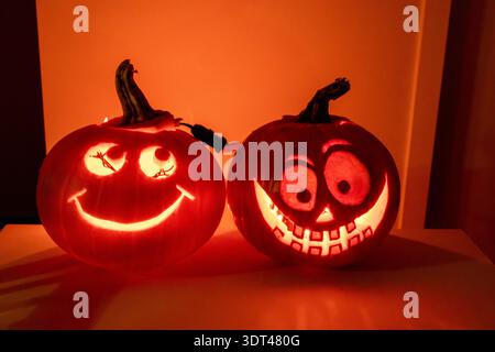 Two glowing carved jack-o-lanterns illuminating a dark room for Halloween in Vancouver Canada Stock Photo