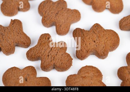 Cookies on white background macro reveals spiced brown cookies with textured surface, scattered arrangement, soft warm light, cozy homemade mood, suit Stock Photo
