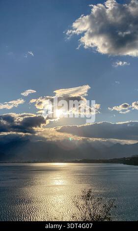 Sunlight breaking through dramatic clouds over Antalya Bay and the Beydaglari Mountains, viewed from near Kaleici Old Town in Antalya, Turkey. Stock Photo