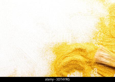 Mosaic of Golden Glitter and Brush Creating Artistic Patterns on a White Background Stock Photo
