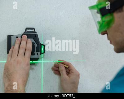 A man measures distance with a laser level.  Stock Photo
