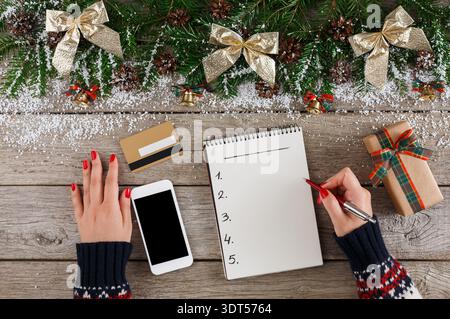 Creating a Holiday Gift List at a Cozy Workspace During the Festive Season Stock Photo