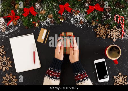 Holiday Gift-Wrapping Scene With Decorations and Tools on a Black Table During Winter Season Stock Photo