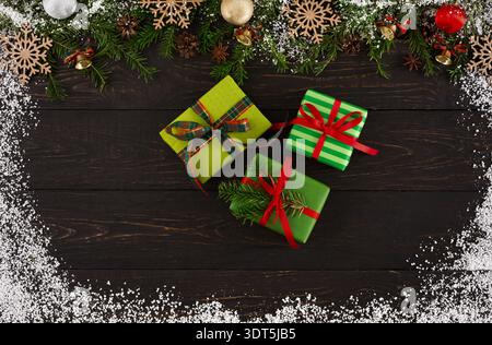 Collage of Gift Boxes Surrounded by Holiday Decorations and Snow on a Dark Wooden Surface Stock Photo