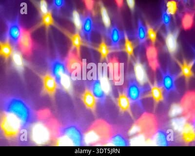 Colorful blurred LED lights creating abstract bokeh background. Festive glowing illumination with blue, yellow and pink tones, holiday decoration conc Stock Photo