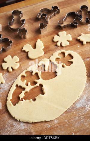 Cutting out Easter shapes from rolled out pastry dough - preparation of homemade Linzer cookies Stock Photo
