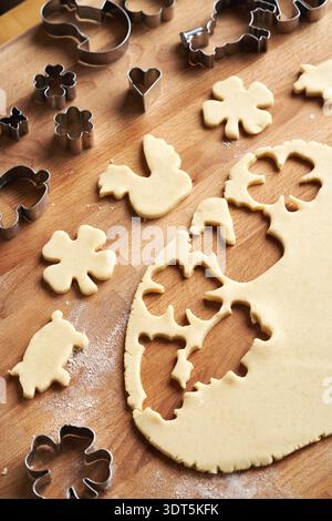 Cutting out Easter shapes from rolled out pastry dough - preparation of homemade Linzer cookies Stock Photo