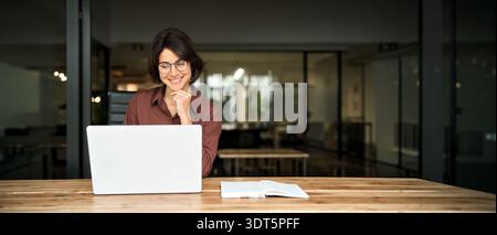 Young happy professional business woman executive working on computer in office. Stock Photo