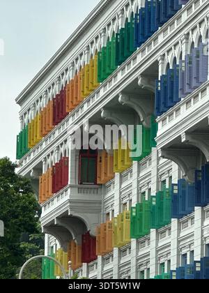 White heritage facade with rainbow shutters and arched balconies, turning city architecture into a color chart Stock Photo