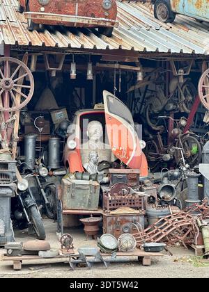 A packed vintage workshop filled with antique tools, wheels, lamps and mechanical treasures — the kind of place where every object probably has three Stock Photo